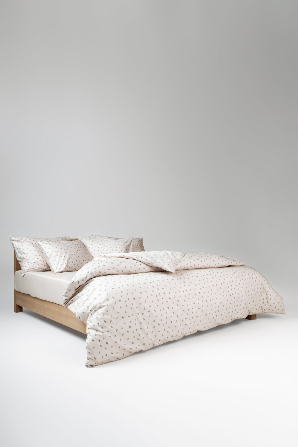 beige bedding with green olive pattern on a bed