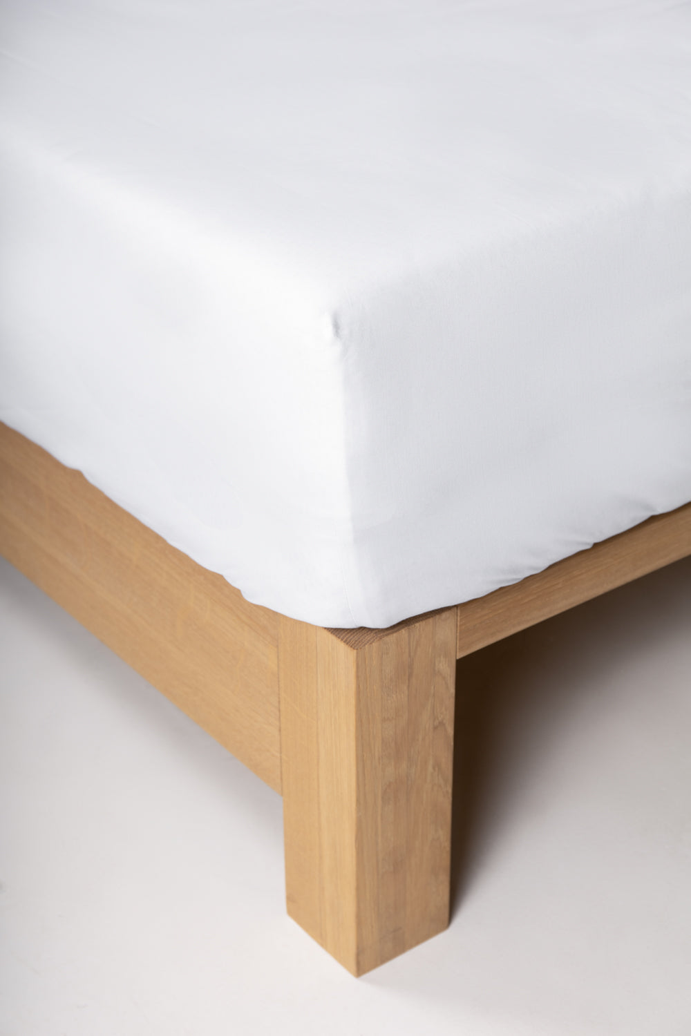 fitted sheet white corner on a wooden bed