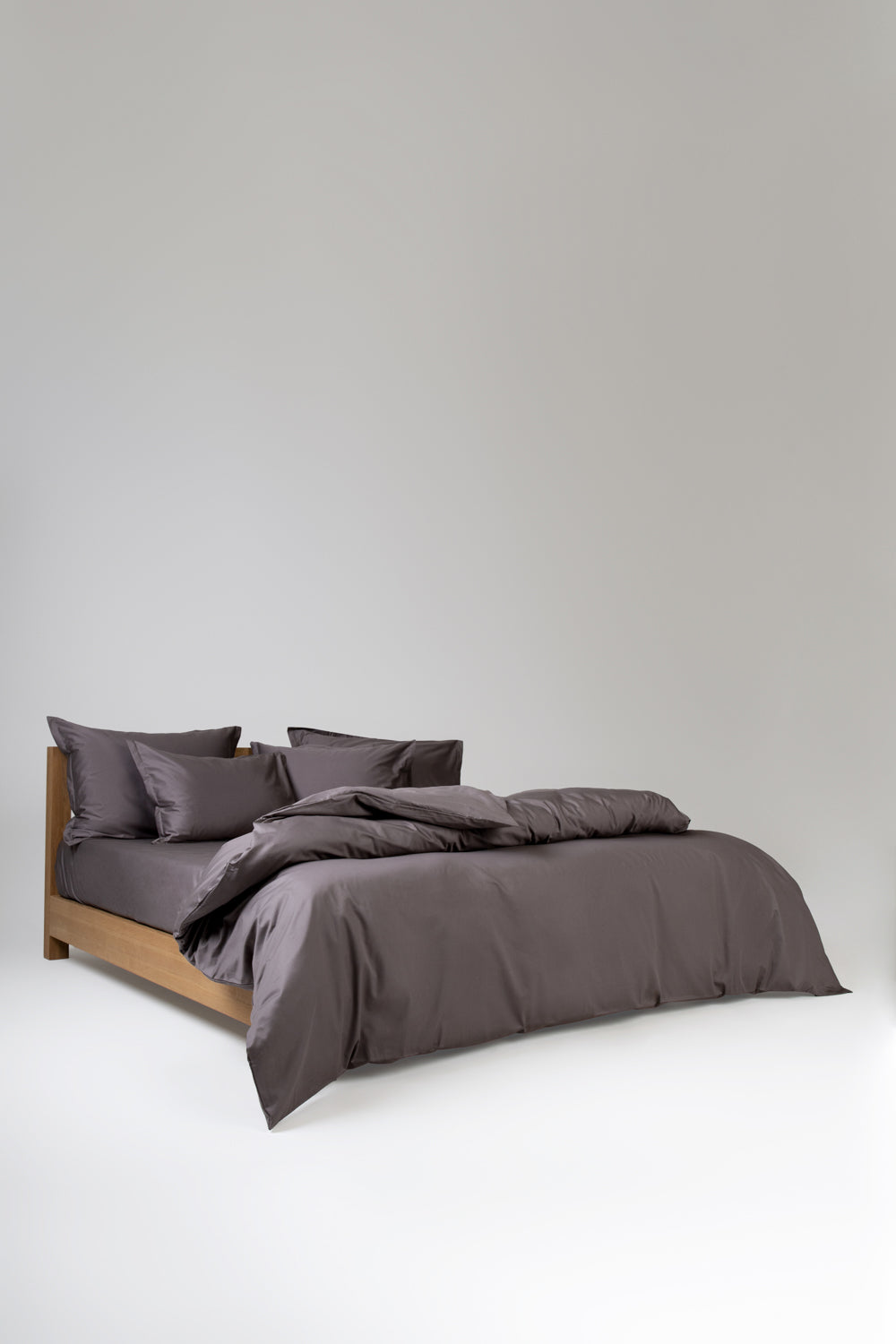gray taupe bedding on a wooden bed