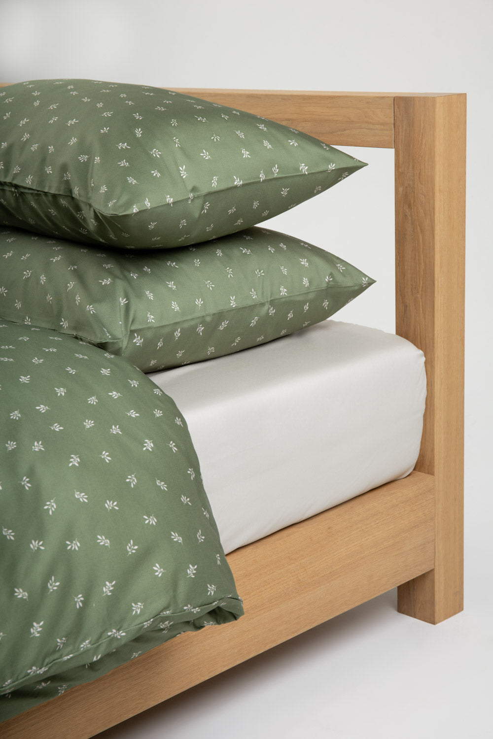 bed with beige sheet and olive green bedding set