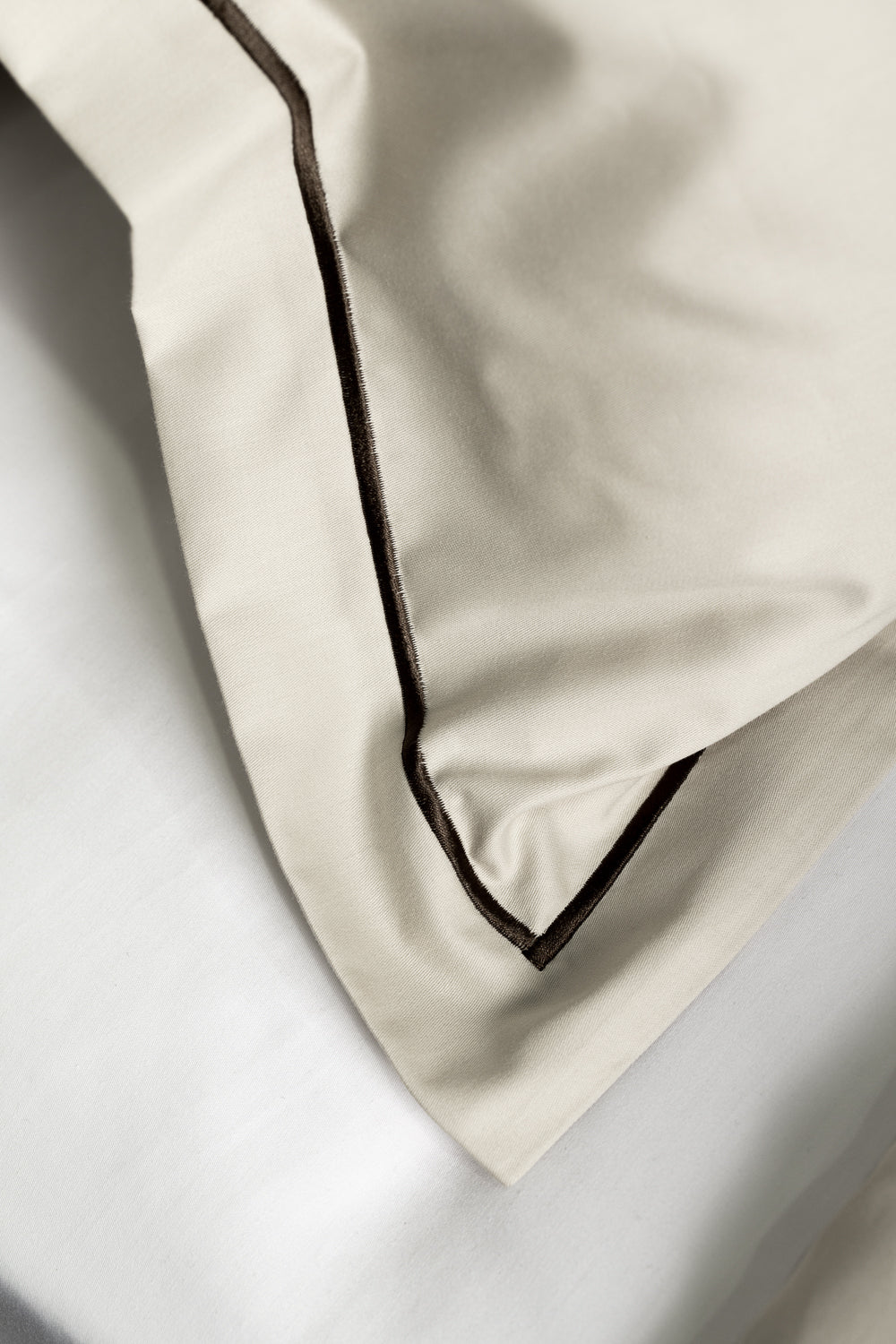 Close-up of beige fabric with a dark border on a light background
