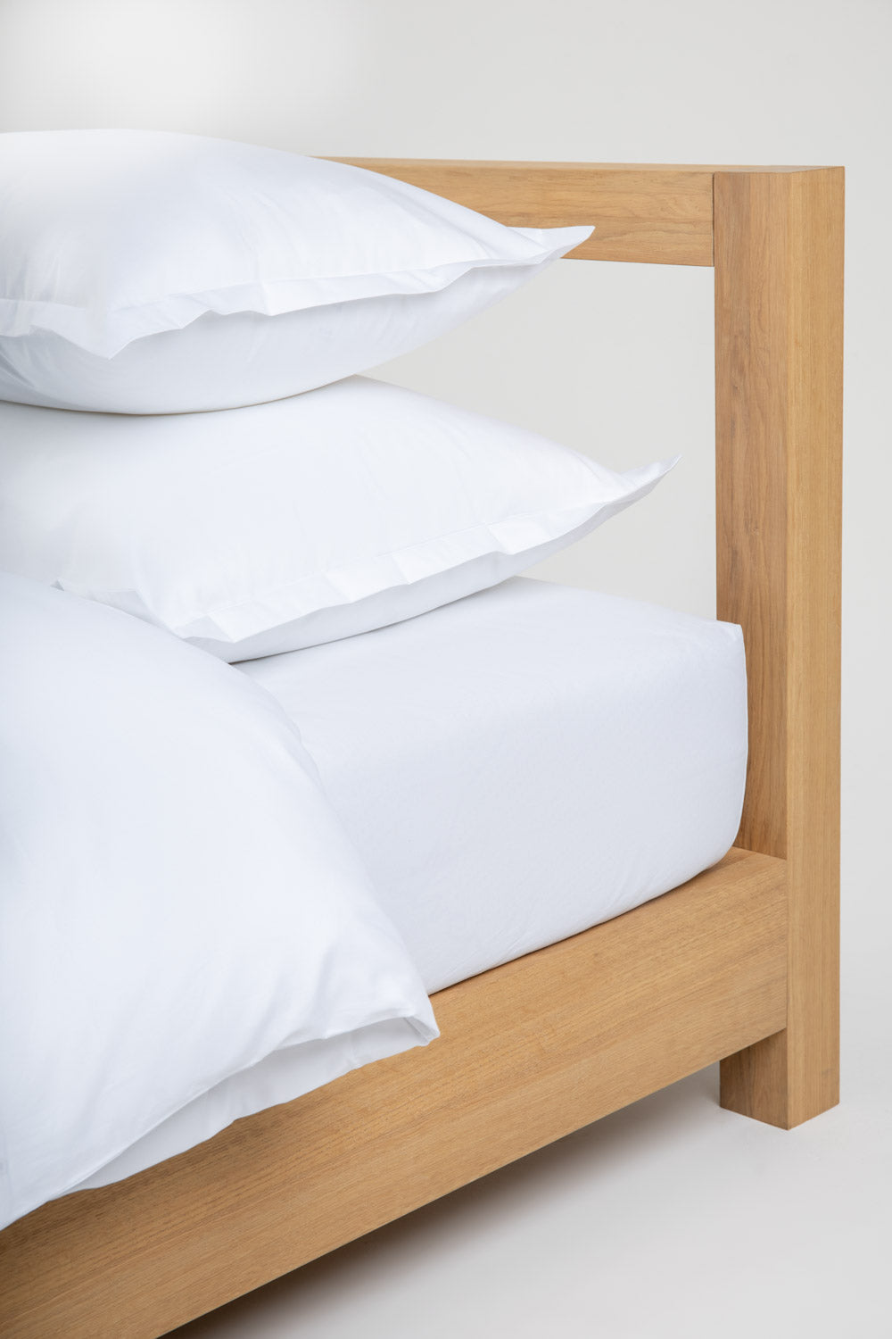 white cotton bedding on a wooden bed