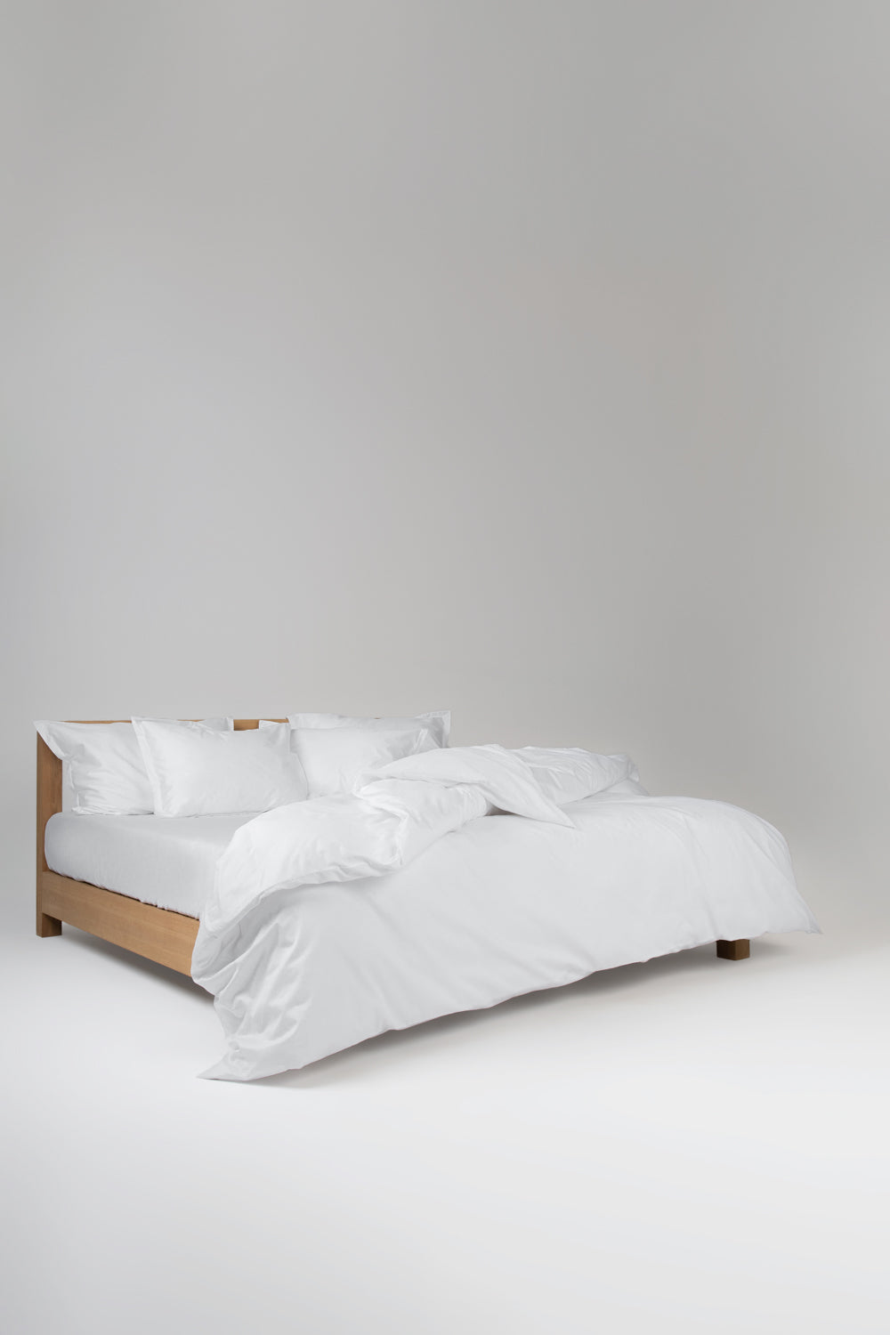 white cotton bedding on a wooden bed